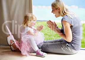 Clap to the beat. A mother and daughter clapping along to a beat and smiling at each other.