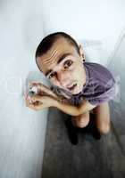 Feeling exposed. A young man stuck in a toilet trying to reach a tiny roll of toilet paper.