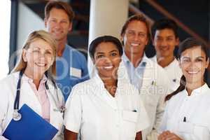 We never fail to deliver. A shot of a group of medical professionals smiling at the camera.