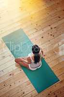 Giving her mind a workout. High angle shot of a young woman doing yoga indoors.