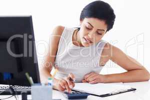 Female accountant calculating financial budget. Attractive female accountant calculating financial budget and taxes at her desk.