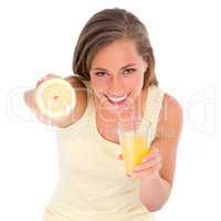 Shes getting her Vitamin C alright. Cropped shot of an attractive young woman drinking orange juice while holding half a lemon.