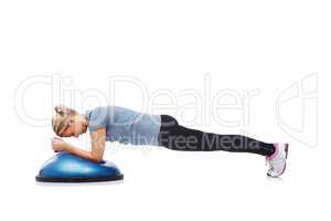 Shes getting into shape. A young woman working her upper body using a bosu-ball.
