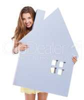 Your home is in good hands. Studio shot of a confident young woman holding a prop of a house in her hands.