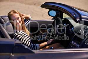 It was worth every penny. Shot of a young woman driving in a sports car.