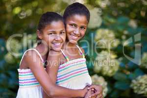 They have that special twin connection. Portrait of two twin sisters standing together outside.