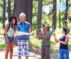 An outdoor experience. Multi-ethnic kids exploring a map while standing outside in a forest.
