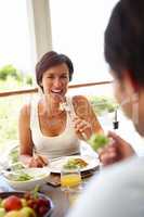 Good food, good mood. Shot of an attractive woman having lunch with an unrecognizable person.
