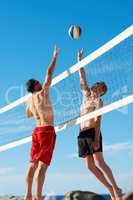 In the heat of the game. Shot of a beach volleyball game on a sunny day.