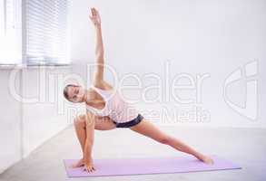 Keeping her mind and body sharp with yoga. An attractive young woman in a yoga position.