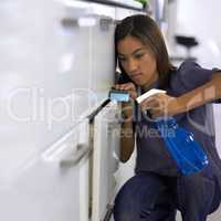 Making sure every surface is spotless. Young woman cleaning the handles of the drawers in a kitchen.