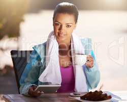 What you eat in private, you wear in public. Cropped shot of a young woman grabbing snack while using her digital tablet after her workout.