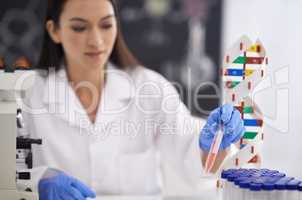 Genetics is her passion. Shot of a female scientist observing a sample in a test tube.