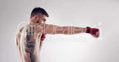 Dropping his opponents with a killer strike. Shot of an MMA fighter in the studio.