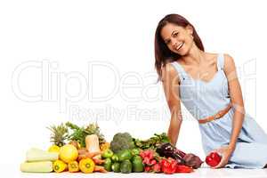 Making healthy choices and feeling great. Smiling young woman alongside an assortment of healthy and fresh vegetables.