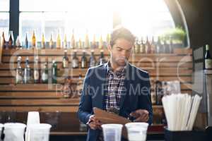 Is this right. Cropped shot of a male bar owner checking his supplies and stock.