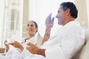 Thorough enjoyment on our spa day. Shot of a loving mature couple enjoying a drink while relaxing together at a day spa.