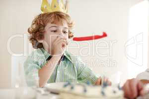 Lets get this party started. Shot of a birthday boy blowing a party horn.