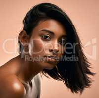 Only thing youll get from me is a boundary. Portrait of a beautiful young woman posing against a brown background.