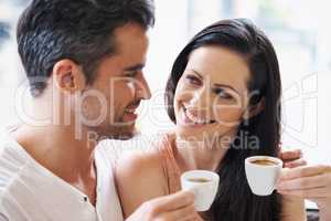 Loving expressions over their espresso. Shot of a young couple grabbing a cup of coffee together.