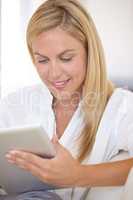 Checking her work schedule. A beautiful young blonde woman working on her digital touchpad.