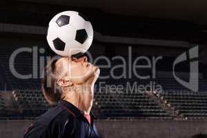 Skill and balance. Shot of a young footballer balancing a ball on his head.