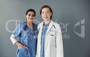 Your health is of the utmost importance. Shot of two young health workers in a hospital in front of grey background.