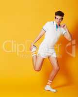 Ready to tone those muscles. A young man doing stretches in front of a yellow background.