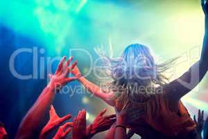 Crowd surfing. A young girl crowd surfing as a band plays one of her favourite songs.