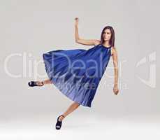 Falling deeper into fashion. Full length shot of a gorgeous brunette floating in a blue dress.