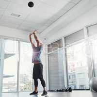 Aim high. Shot of a young man working out at the gym.