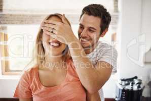 Love isnt something you see, its something you feel. Shot of a young man playfully covering his girlfriends eyes at home.