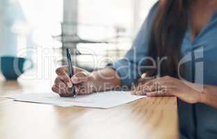 Her signature seals the deal. Closeup shot of an unrecognisable businesswoman filling in paperwork in an office.