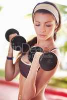 Working for the body I want. Shot of an attractive young woman working out with dumbells.