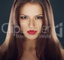 Intense beauty. A portrait of a beautiful brunette wearing bright red lipstick.