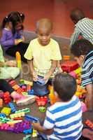 Sharing is caring. Play time for a group of young children who are playing with plastic blocks.