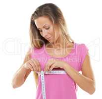 Measuring for a bra. Studio shot of a gorgeous woman measuring her bust with a measuring tape against a white background.