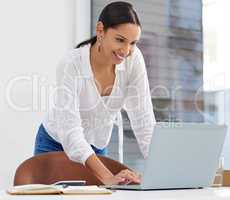 Maybe staring at the screen will make it work faster. shot of a young businesswoman using a laptop in a modern office.