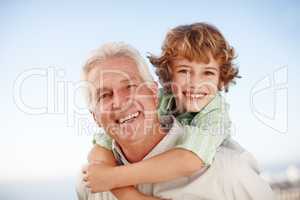 Hell carry on our familys name. Cropped portrait of a young boy getting piggybacked by his grandfather.