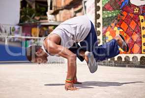 Capoeira culture. Low angle shot of a young male breakdancer in an urban setting.