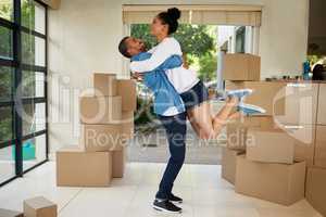They cant contain their excitement. Shot of a happy young couple celebrating their move into a new home.