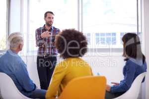 Explanation is an artform. Shot of a group of coworkers in a meeting.