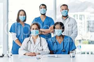 Teamwork allows us to cut down on medical errors. Portrait of a group of medical practitioners having a meeting in a hospital boardroom.