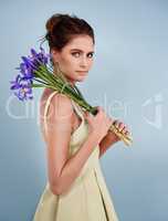 Looking lovely with lavender. Cropped shot of an attractive young woman holding flowers against a gray background.