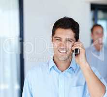 Call centres make life simple. Head and shoulders shot of a young man using his cellphone.