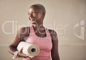 I just had a great yoga session. Cropped shot of an attractive young woman standing alone and holding her yoga mat before an indoor yoga session.