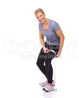 Building her strength. Studio shot of an attractive young woman measuring her workout progress with a tape measure.