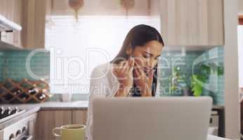 I think I bit my gum thats so painful. Shot of a young businesswoman suffering from a tooth ache while eating an apple at home.
