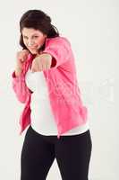 One pound at a time. Studio shot of a young woman throwing punches while wearing exercise clothing.