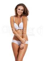Its a little chilly in here. Portrait of a beautiful young woman standing in her underwear isolated on white.